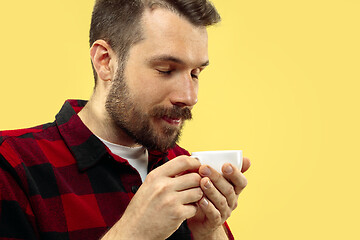 Image showing Half-length close up portrait of young man on yellow background.