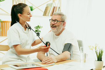 Image showing The visiting nurse taking care of senior man