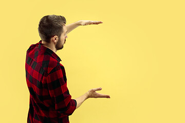 Image showing Half-length close up portrait of young man on yellow background.