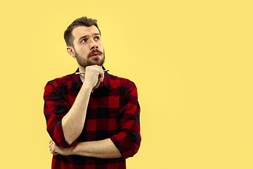 Image showing Half-length close up portrait of young man on yellow background.