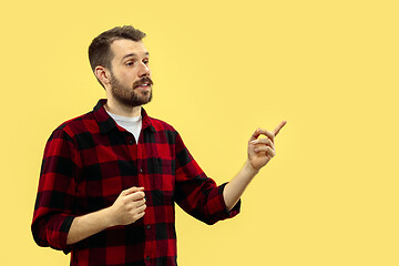 Image showing Half-length close up portrait of young man on yellow background.