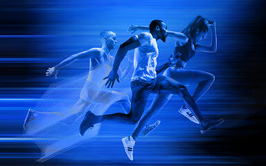 Image showing Young african-american and caucasian men and woman running isolated on blue studio background