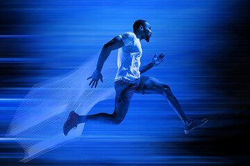 Image showing Young african-american man running isolated on blue studio background