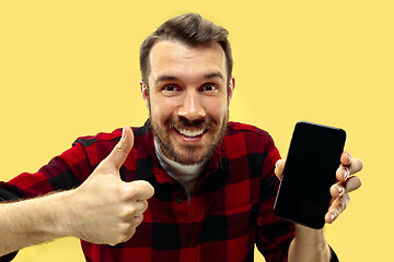 Image showing Half-length close up portrait of young man on yellow background.