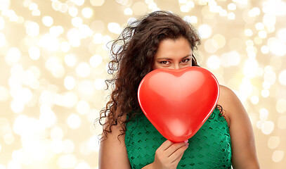 Image showing playful woman holding red heart shaped balloon