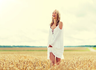 Image showing smiling young woman in white dress on cereal field