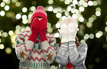 Image showing couple in ugly sweaters and mittens on christmas