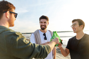 Image showing young men toasting non alcoholic beer on beach