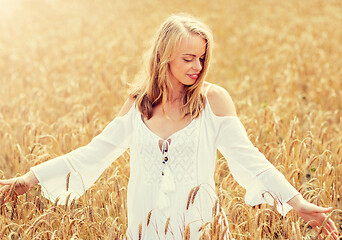 Image showing smiling young woman in white dress on cereal field