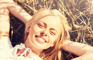 Image showing happy young woman lying on cereal field