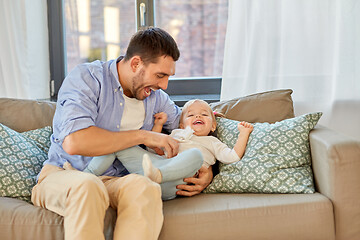 Image showing happy father tickling little baby daughter at home