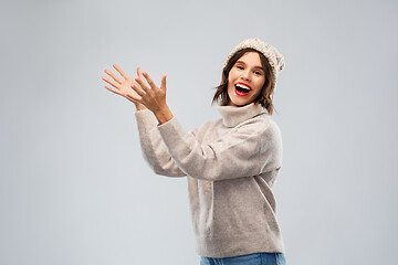 Image showing woman in hat and sweater holding something