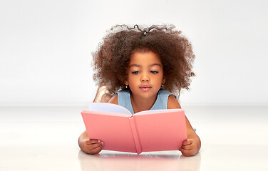 Image showing happy little african girl reading book