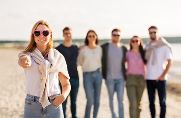 Image showing woman with friends on beach pointing to you