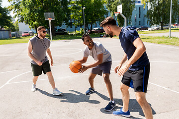 Image showing group of male friends playing street basketball