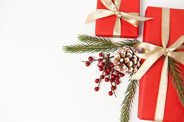 Image showing christmas gifts and fir branches with pine cones