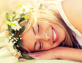 Image showing happy woman in wreath of flowers lying