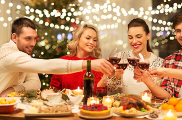 Image showing happy friends drinking red wine at christmas party