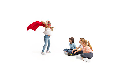 Image showing Child pretending to be a superhero with her friends sitting around