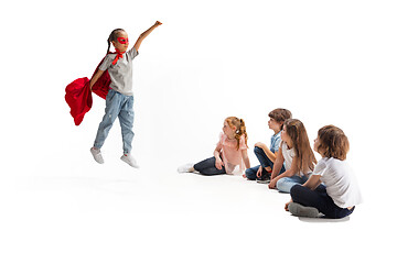 Image showing Child pretending to be a superhero with her friends sitting around