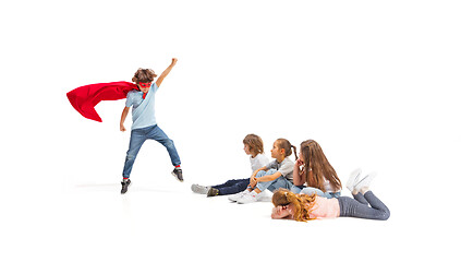 Image showing Child pretending to be a superhero with his friends sitting around