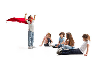 Image showing Child pretending to be a superhero with her friends sitting around