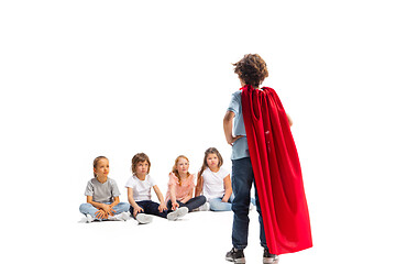 Image showing Child pretending to be a superhero with his friends sitting around