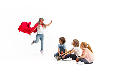 Image showing Child pretending to be a superhero with her friends sitting around