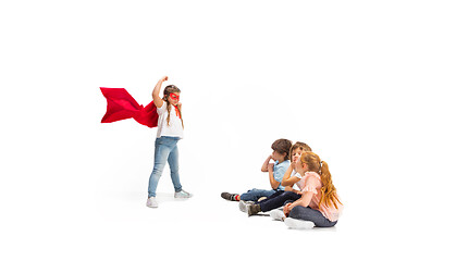 Image showing Child pretending to be a superhero with her friends sitting around