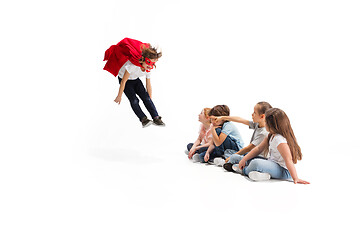 Image showing Child pretending to be a superhero with his friends sitting around