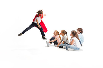 Image showing Child pretending to be a superhero with his friends sitting around