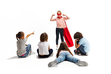 Image showing Child pretending to be a superhero with her friends sitting around