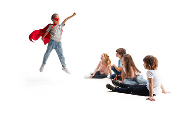 Image showing Child pretending to be a superhero with her friends sitting around