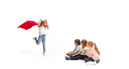 Image showing Child pretending to be a superhero with her friends sitting around