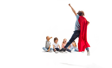 Image showing Child pretending to be a superhero with his friends sitting around