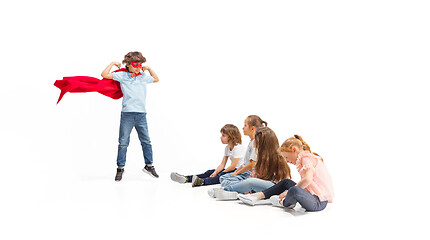 Image showing Child pretending to be a superhero with his friends sitting around