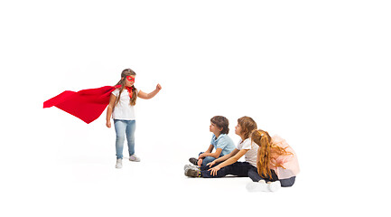Image showing Child pretending to be a superhero with her friends sitting around