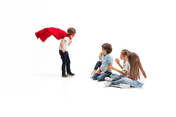 Image showing Child pretending to be a superhero with his friends sitting around