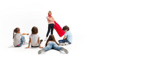 Image showing Child pretending to be a superhero with her friends sitting around