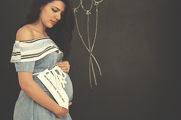 Image showing Portrait of pregnant woman in front of black chalkboard