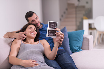 Image showing pregnant couple looking baby\'s ultrasound