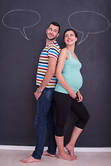 Image showing pregnant couple writing on a black chalkboard