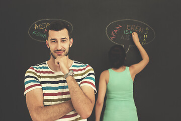 Image showing pregnant couple writing on a black chalkboard
