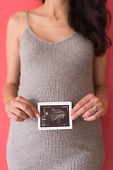 Image showing happy pregnant woman showing ultrasound picture