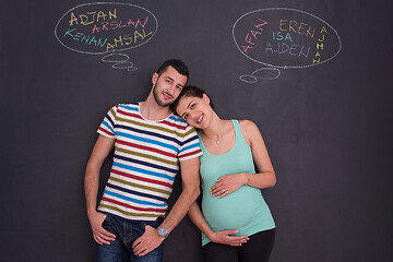 Image showing pregnant couple writing on a black chalkboard
