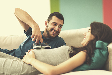 Image showing young pregnant couple relaxing on sofa