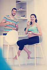 Image showing couple eating fruit strawberries at kitchen