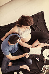 Image showing top view of couple checking a list of things for their unborn ba