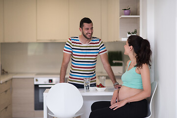 Image showing couple eating fruit strawberries at kitchen