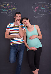 Image showing pregnant couple writing on a black chalkboard